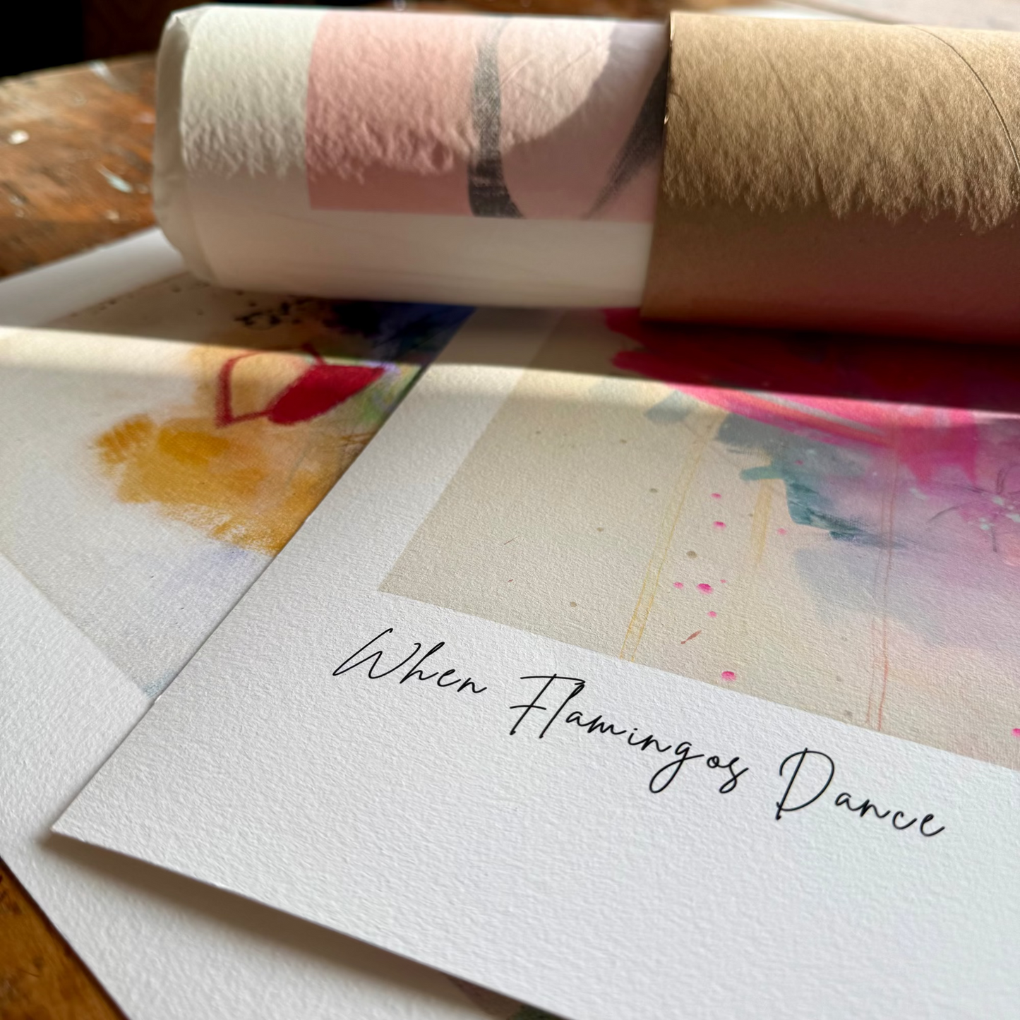 Roll of paper with watercolor designs and a card with 'When Flamingos Dance' text.
