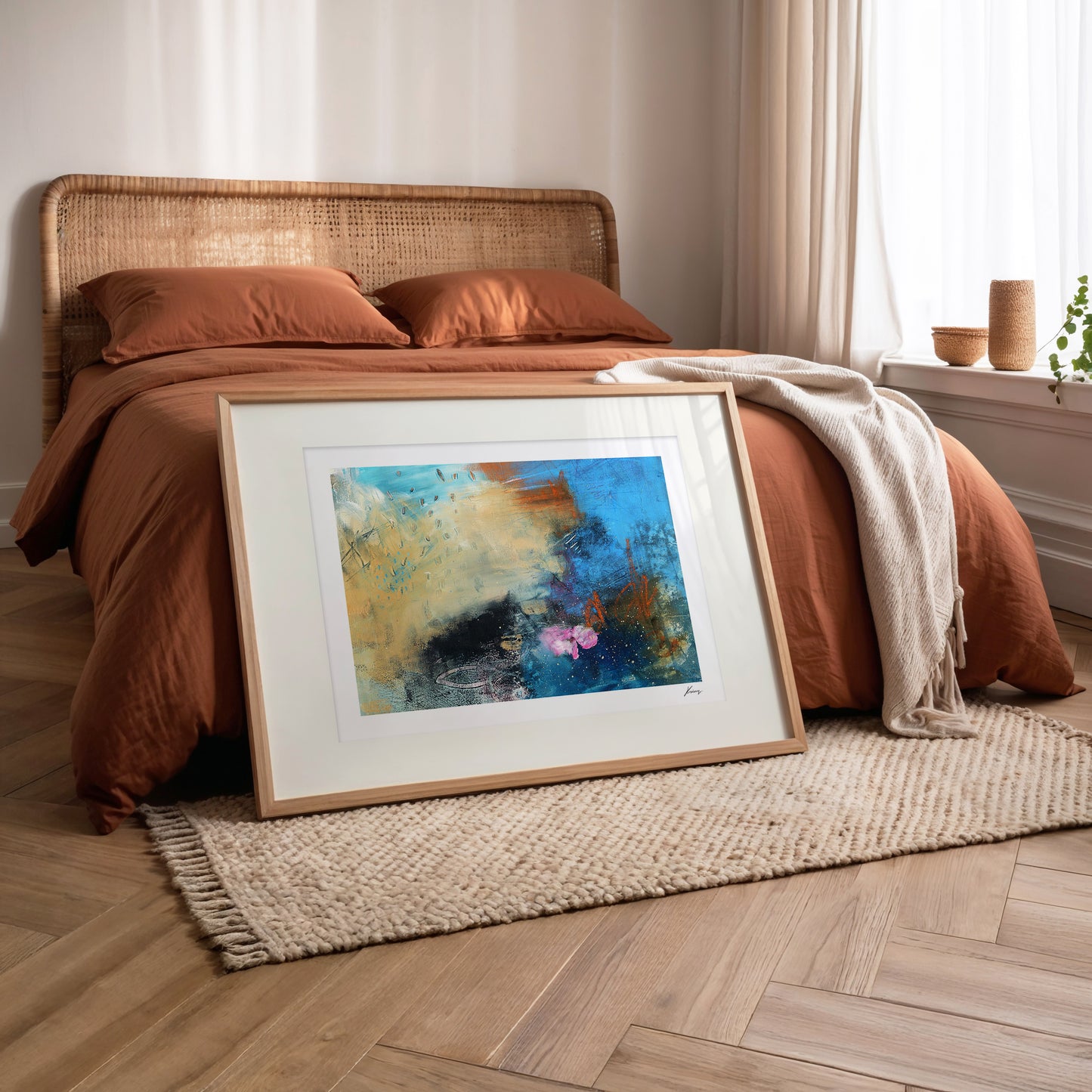 Framed abstract painting on a wooden floor in a bedroom setting