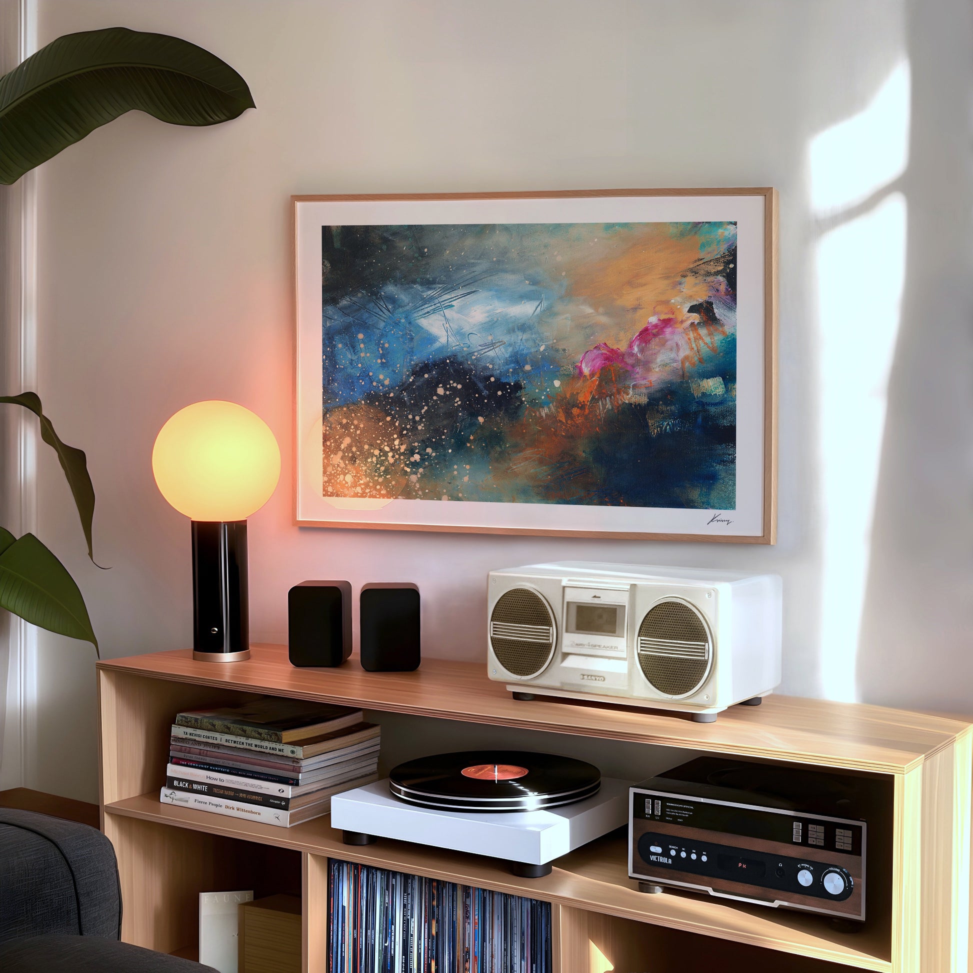 Wooden entertainment console with vintage radio, speakers, and records in a room with abstract art and plant.