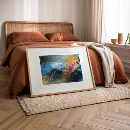 Framed abstract painting on a wooden floor in a bedroom setting