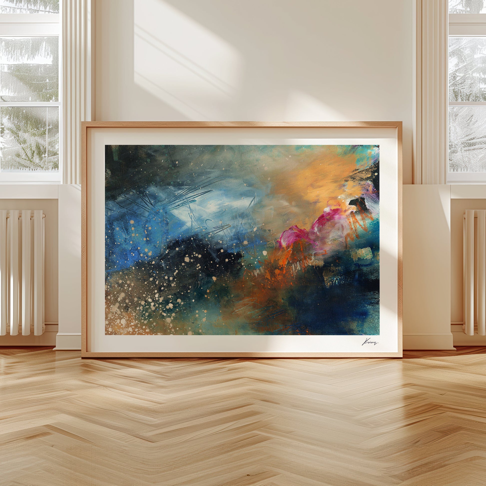 Framed abstract painting on a wall with large windows and wooden floor