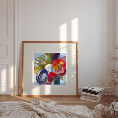 Framed abstract artwork on a wall with books and decor items below