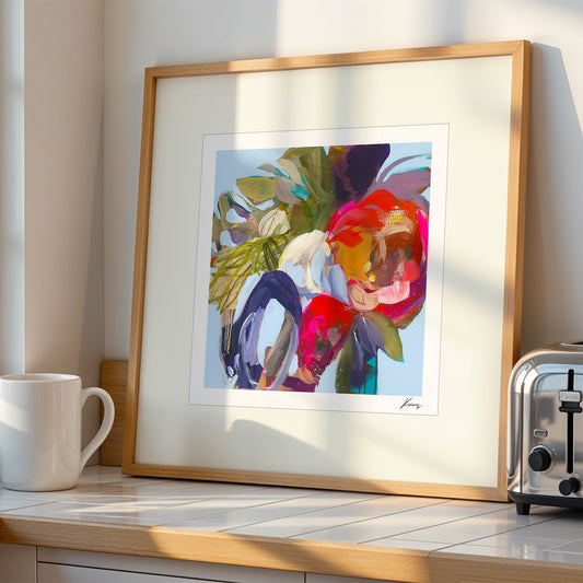 Framed colorful abstract art on a kitchen counter with a mug and toaster.