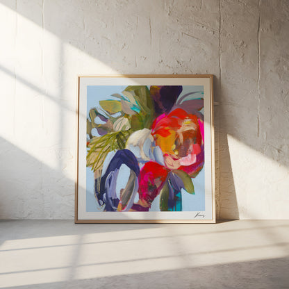 Framed abstract art print with vibrant colors on a white wall.