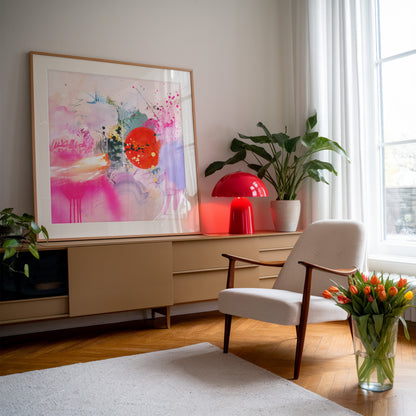 Framed abstract art print styled in a retro room with red lamp and flowers