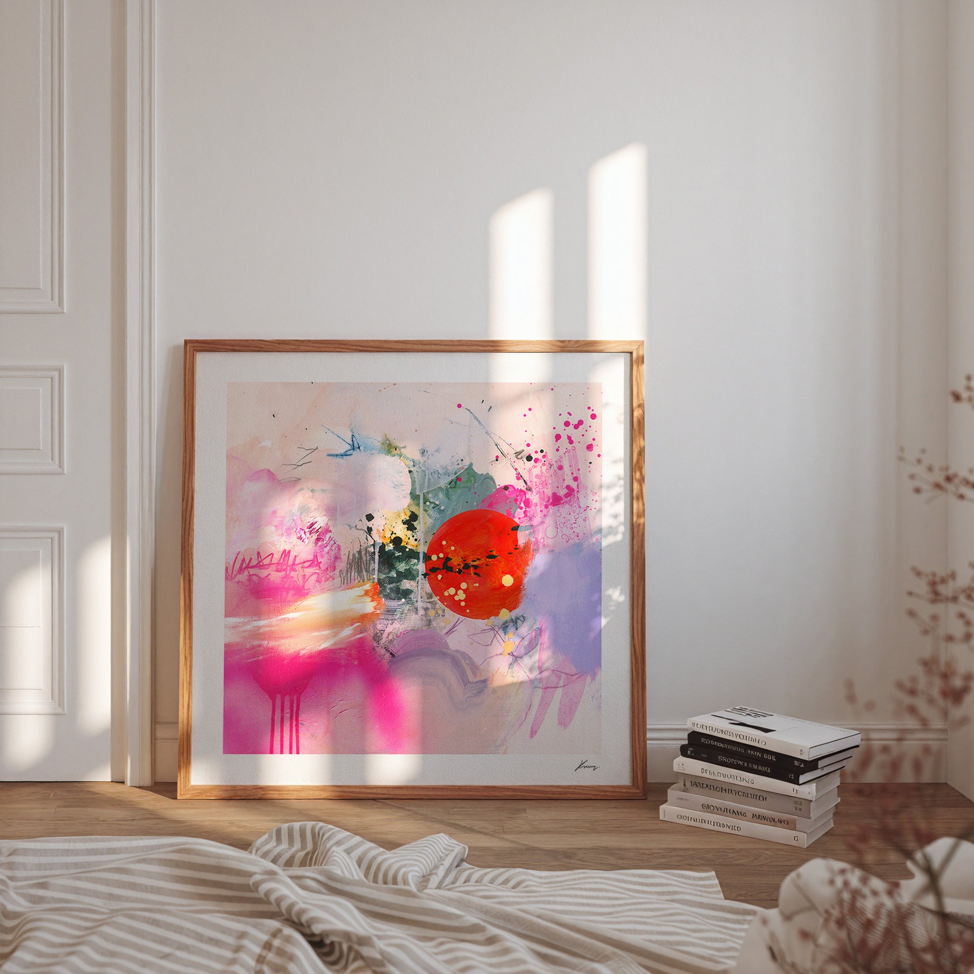 Framed abstract art print in a bedroom with books