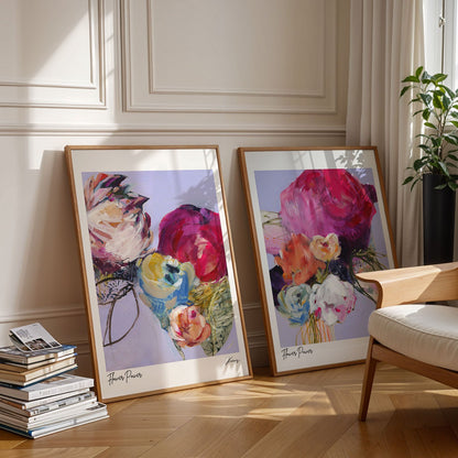 Two framed floral artworks on a wall in a room with a chair and books.