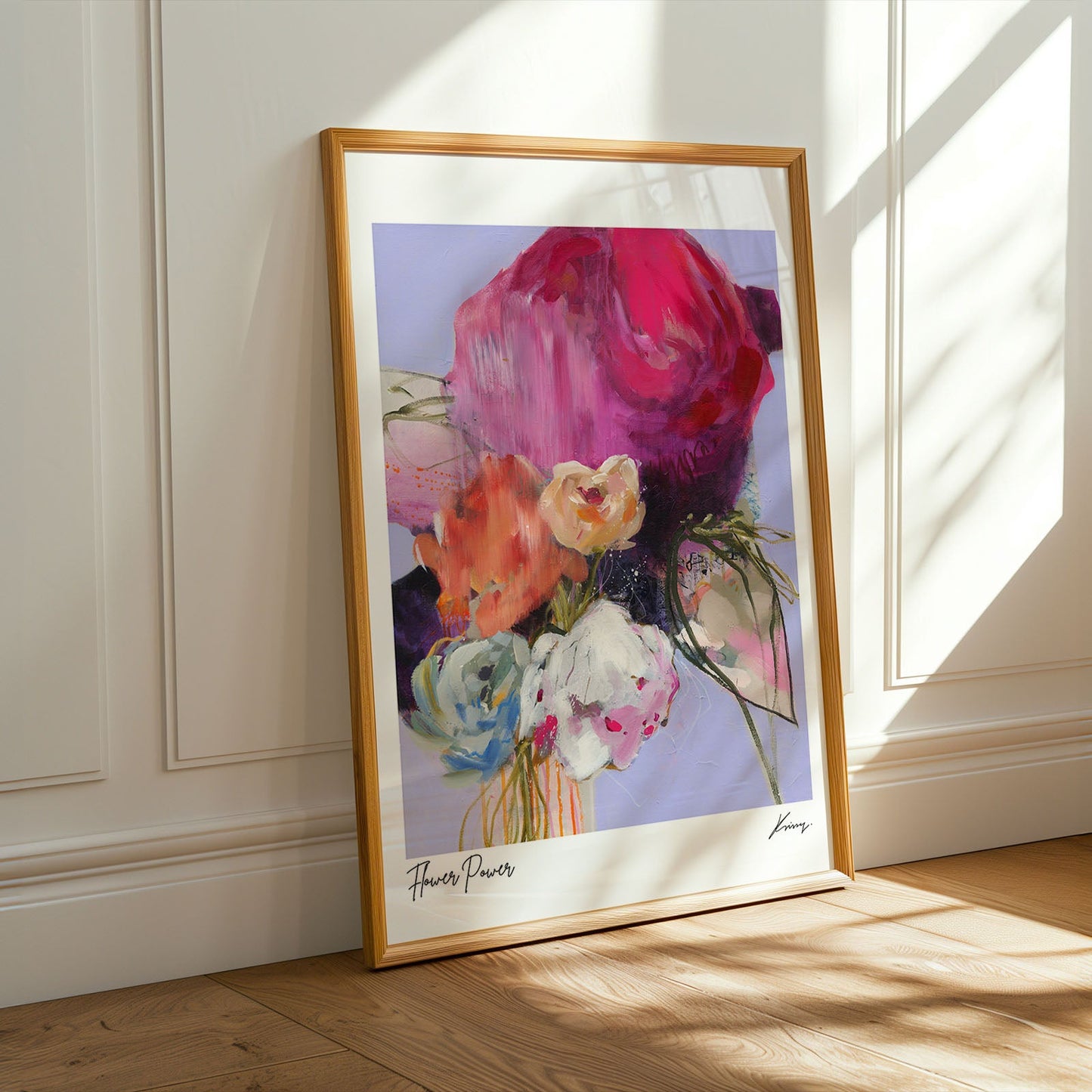 Framed abstract art print on a wall with sunlight casting shadows