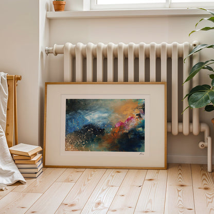 Framed abstract painting on a wooden floor with a radiator and plant in the background