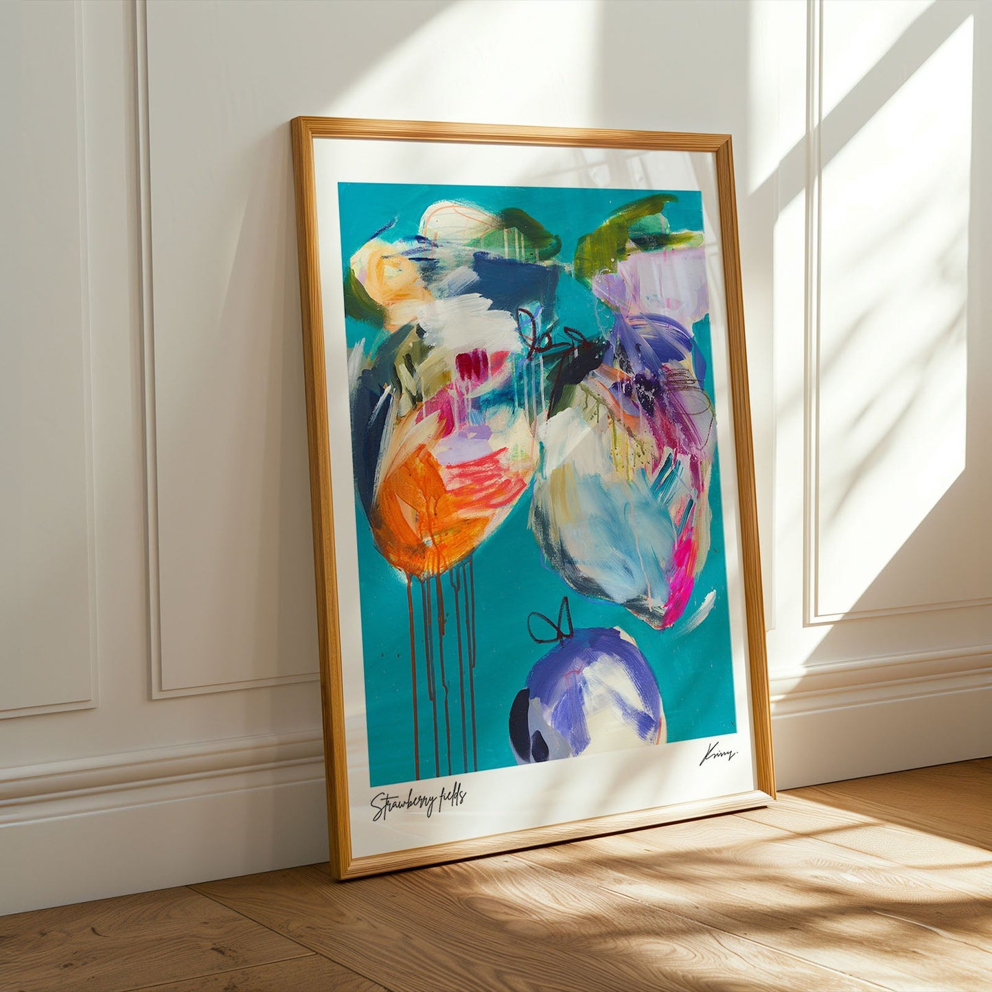 Framed abstract artwork with colorful flowers on a white wall.