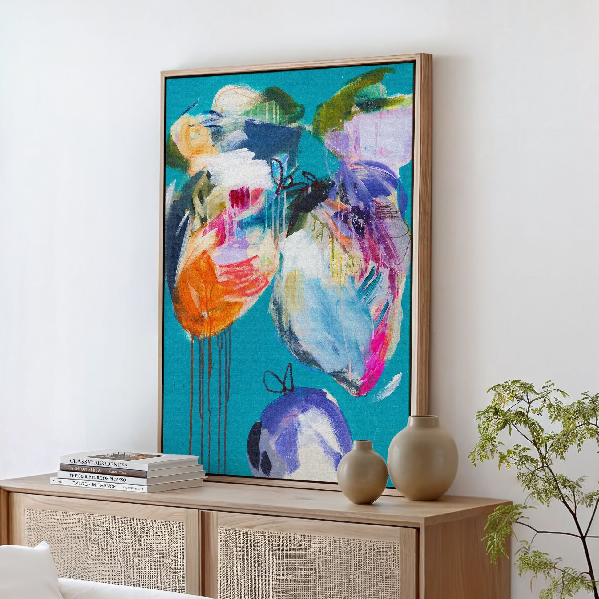 Colorful abstract painting on a wall above a wooden console table with decorative items.