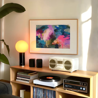 Wooden shelf with stereo equipment, books, and a colorful abstract painting on a wall.