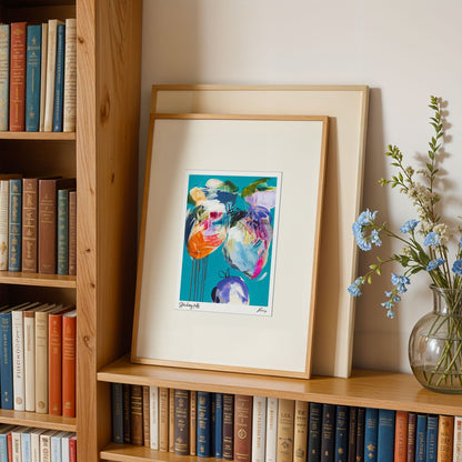 Framed artwork on a bookshelf with books and a vase of flowers.