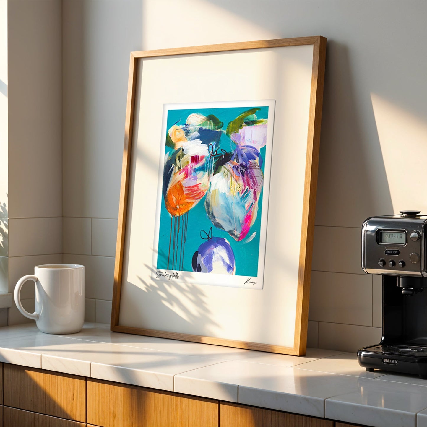 Colorful abstract painting on a kitchen counter with a coffee machine and mug.