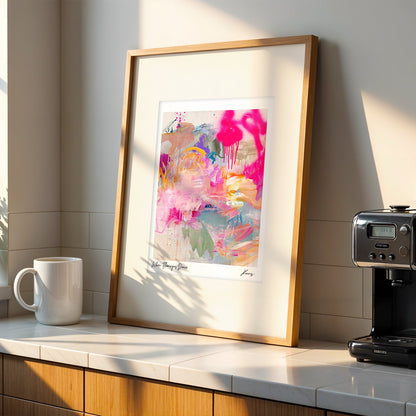 Modern kitchen with a coffee machine, mug, and abstract art on a white countertop.