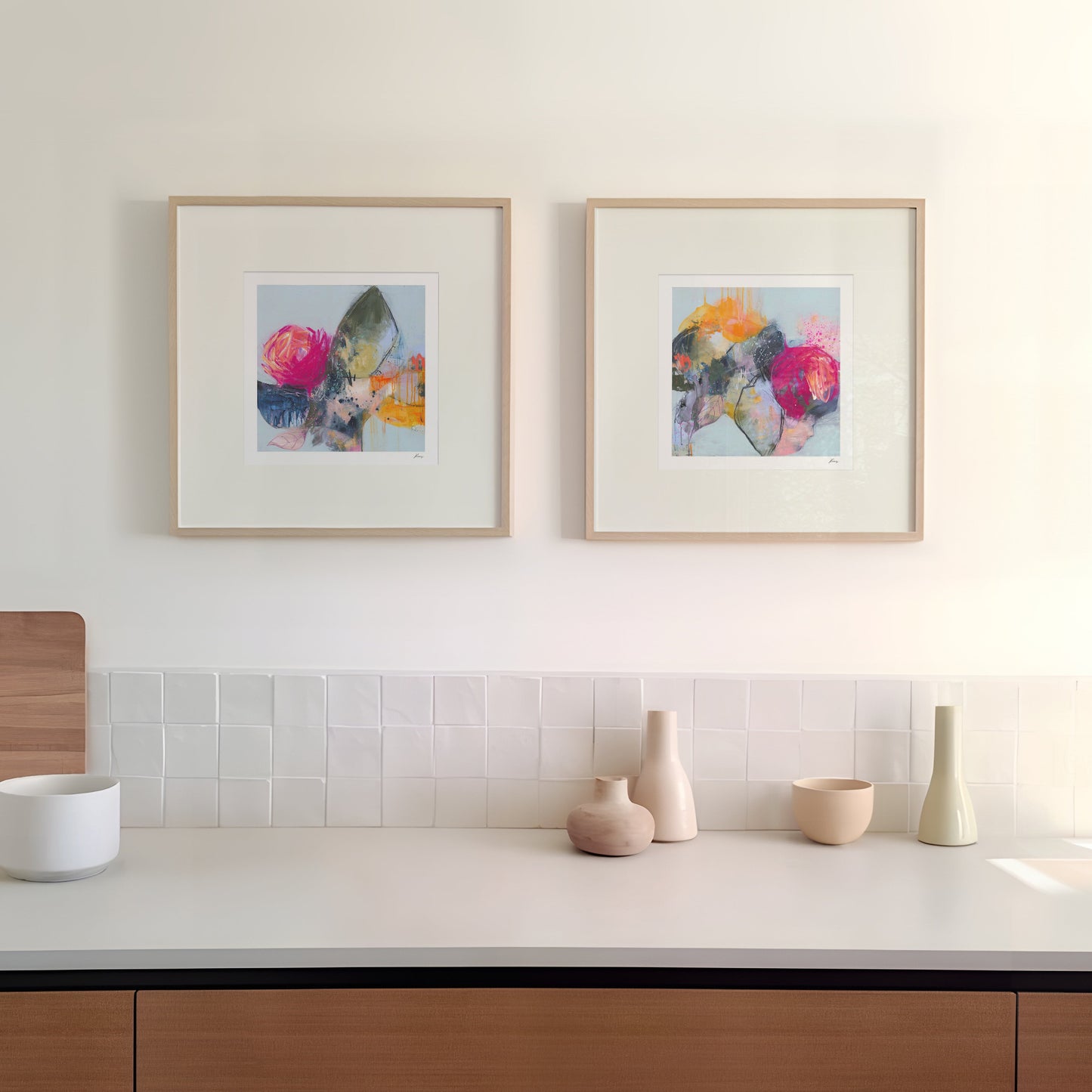 Modern kitchen with wooden cabinets, white countertop, and framed artwork on the wall.