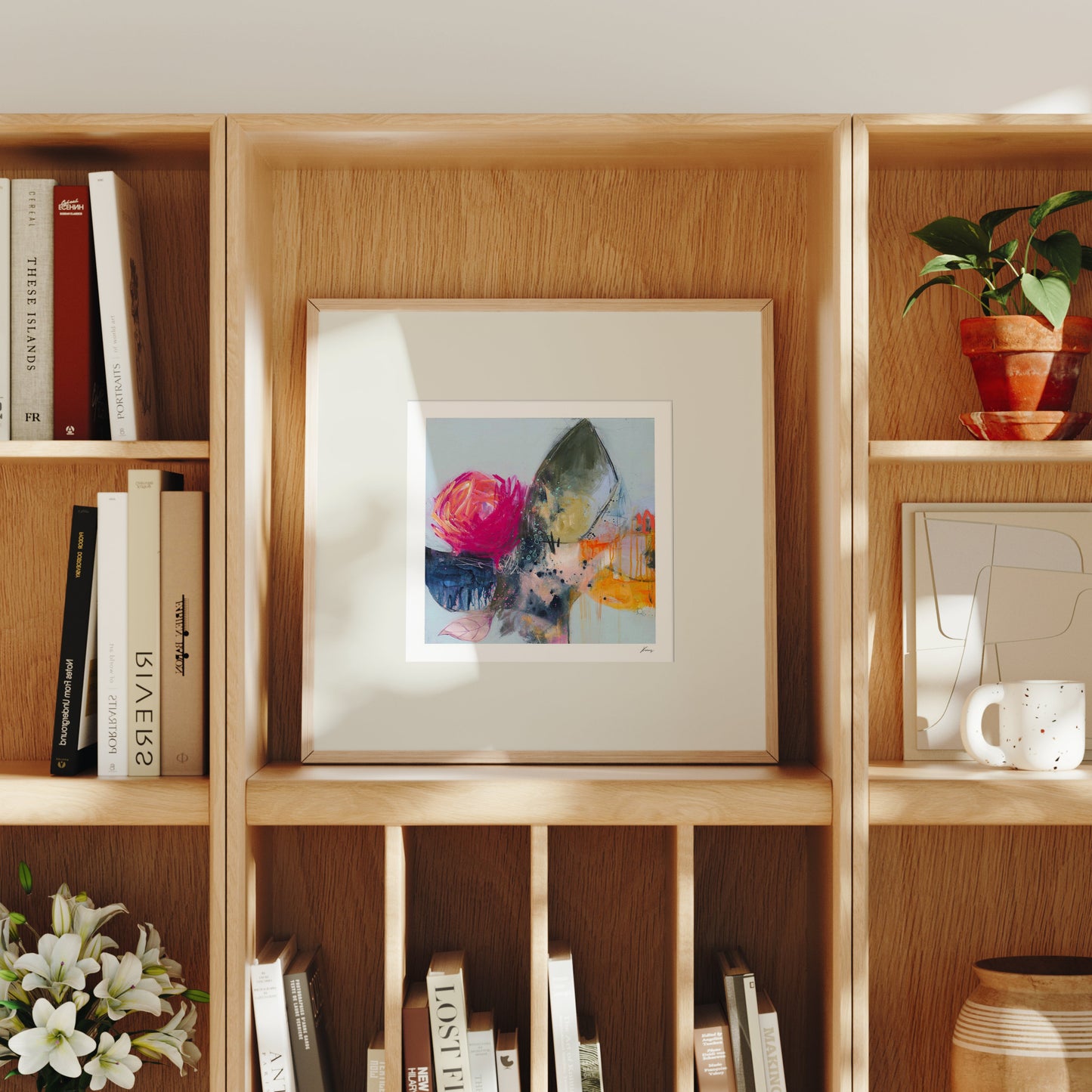 Wooden bookshelf with books, a framed picture, and decorative items.