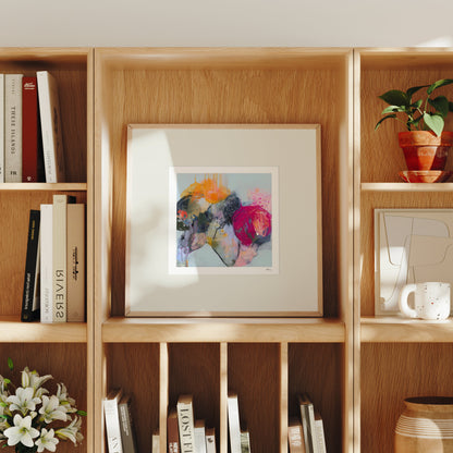 Wooden bookshelf with books, a framed picture, and decorative items.