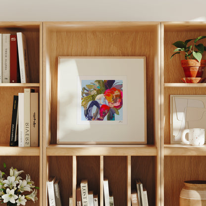 Wooden bookshelf with books, a framed abstract painting, and decorative items.