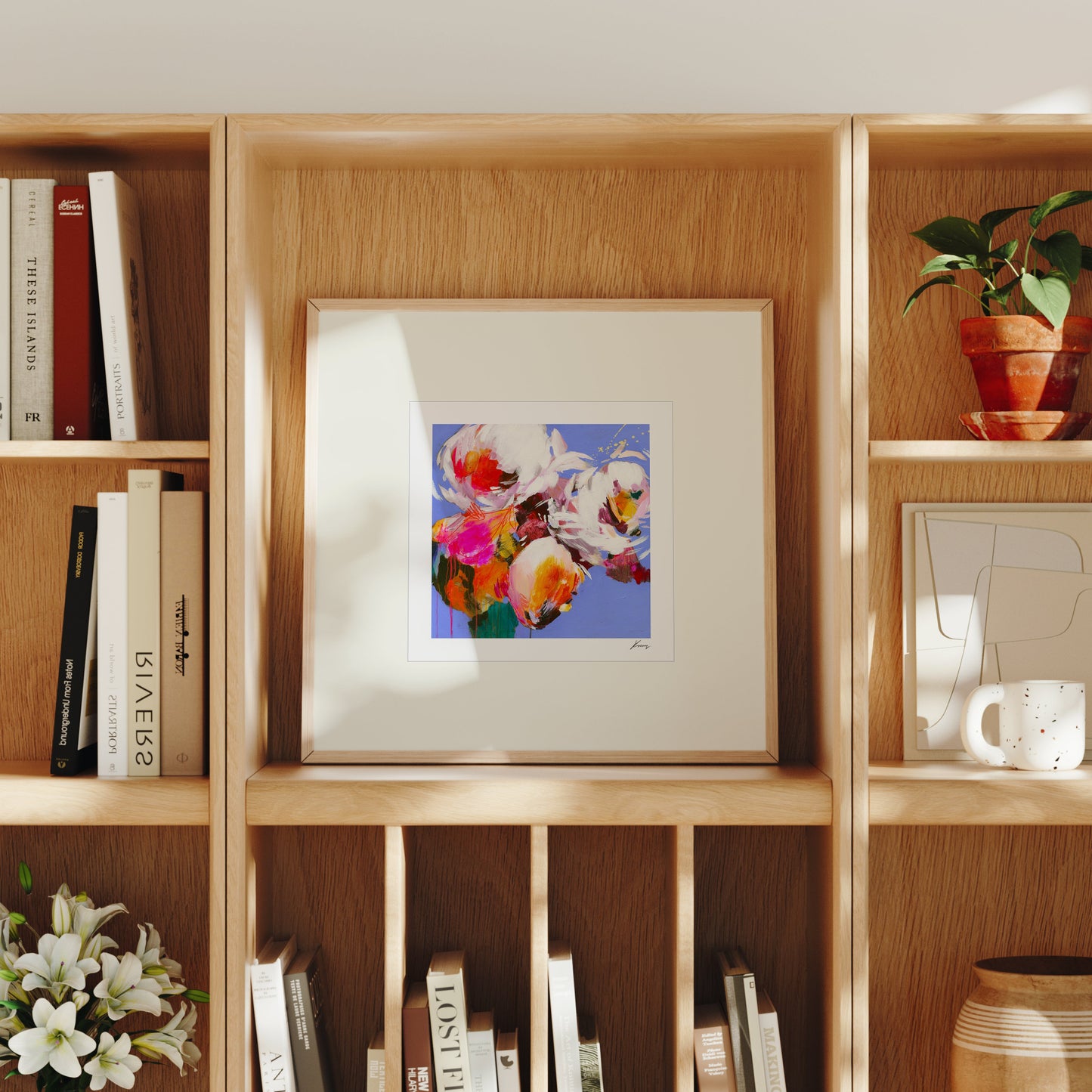 Wooden bookshelf with books, a framed artwork, and decorative items.